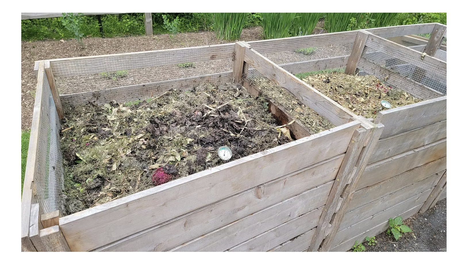 Wooden compost bins filled with decomposing organic waste